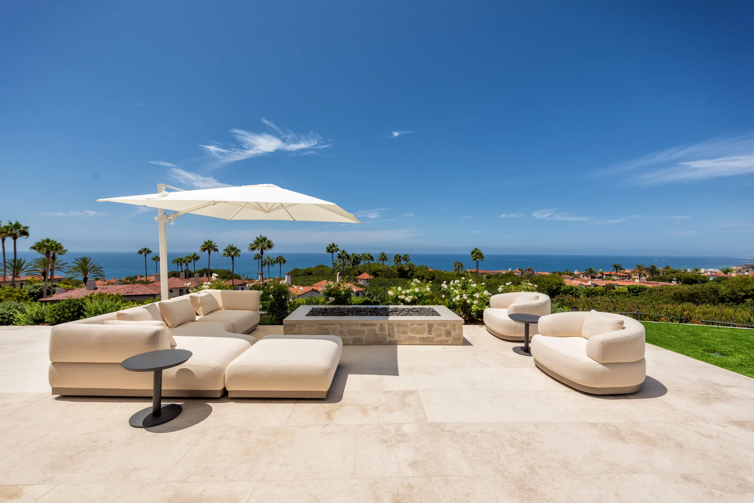 A cozy outdoor seating area with a fire feature and sun umbrella