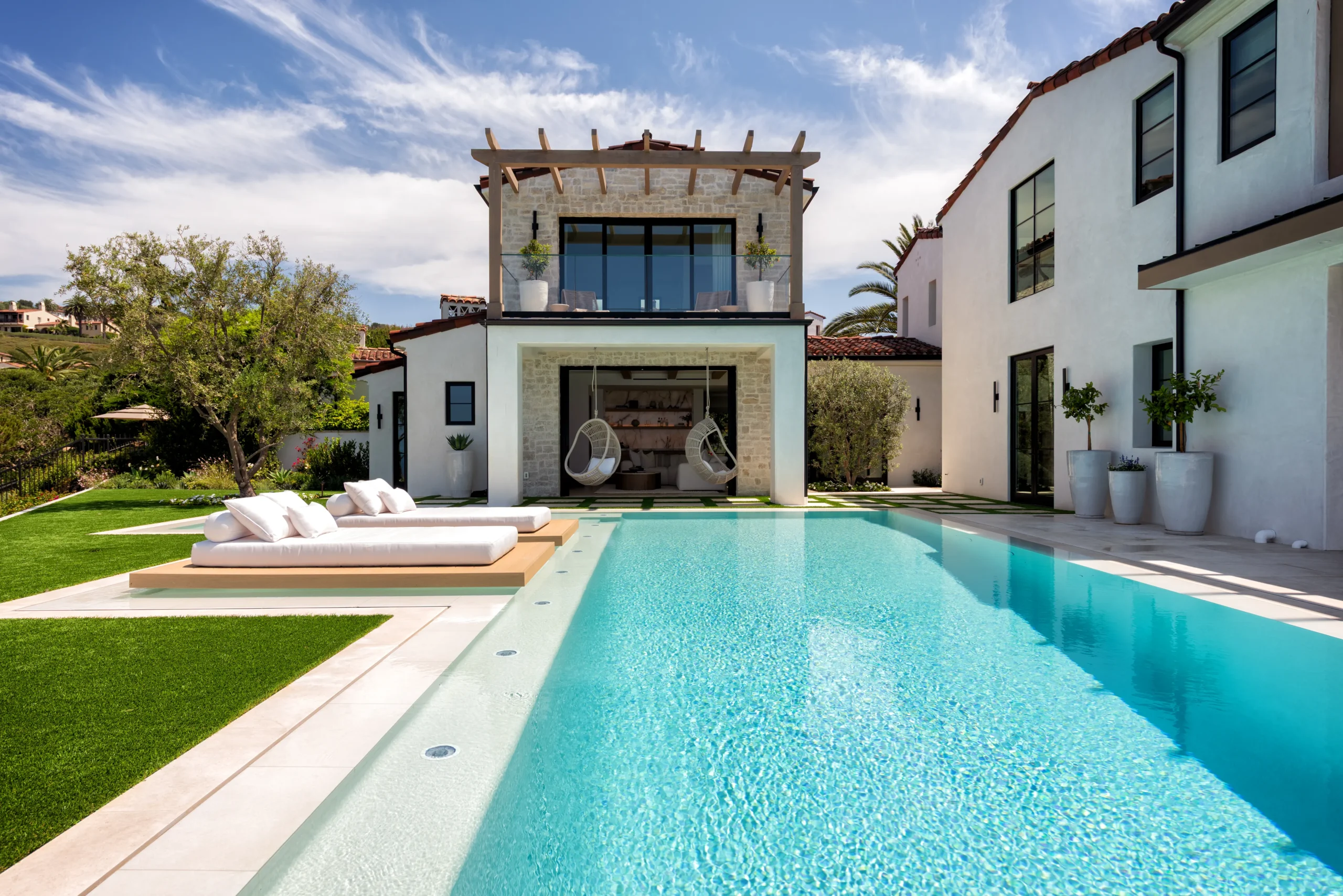 Pool with a shallow lounge area, floating daybeds and hanging chairs